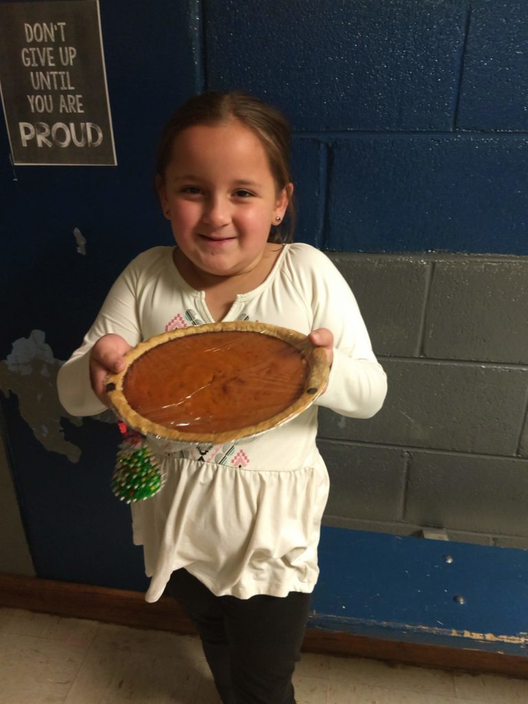 girl holding a pumpkin pie