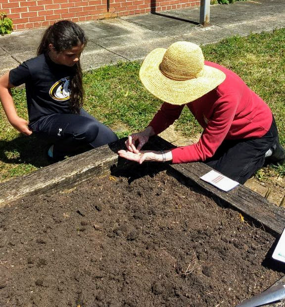 volunteer gardener teaching a child