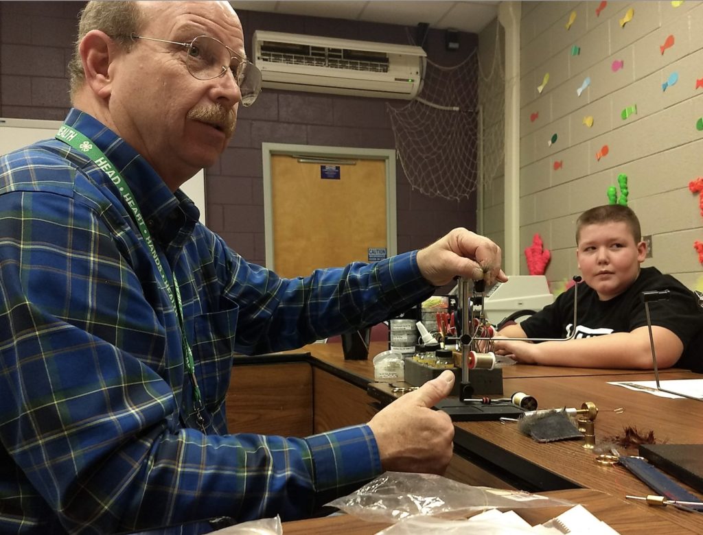 Volunteer teaching youth to tie flies