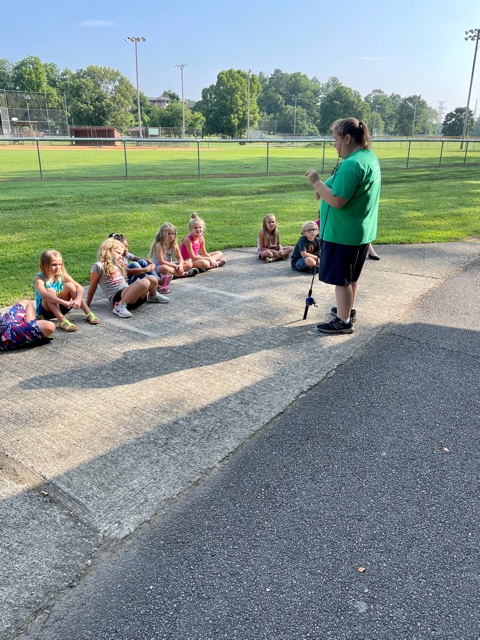 Woman speaking to seated kids