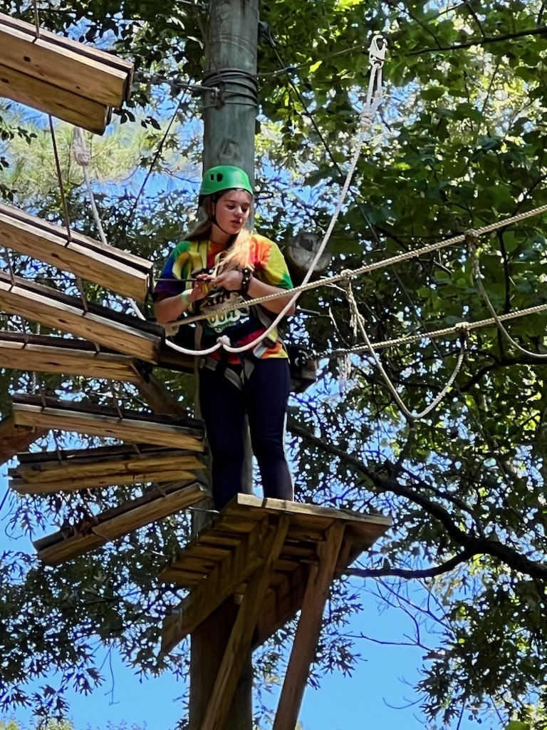 A camper doing a high ropes course