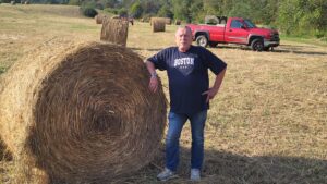 Field with hay equipment and round hay bales